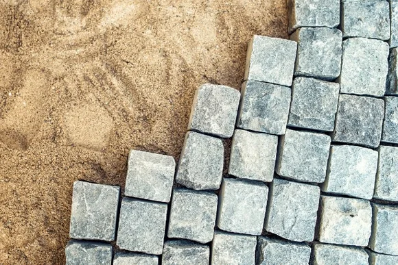 Graue Pflastersteine auf Sand